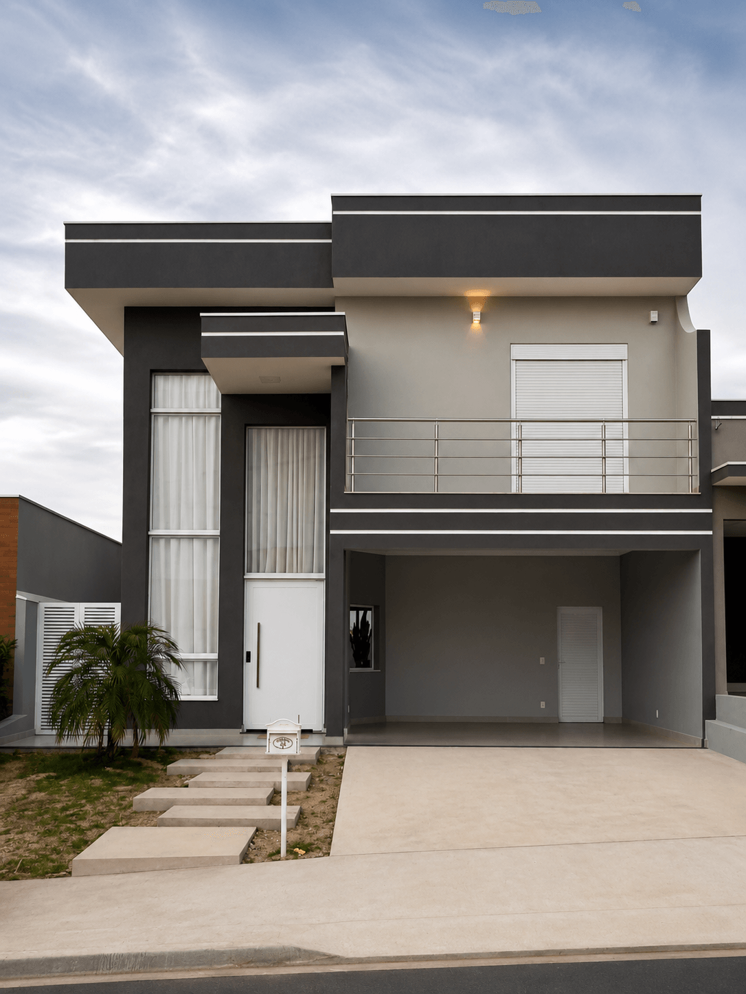 Fachada residencial moderna com revestimentos em tons de cinza